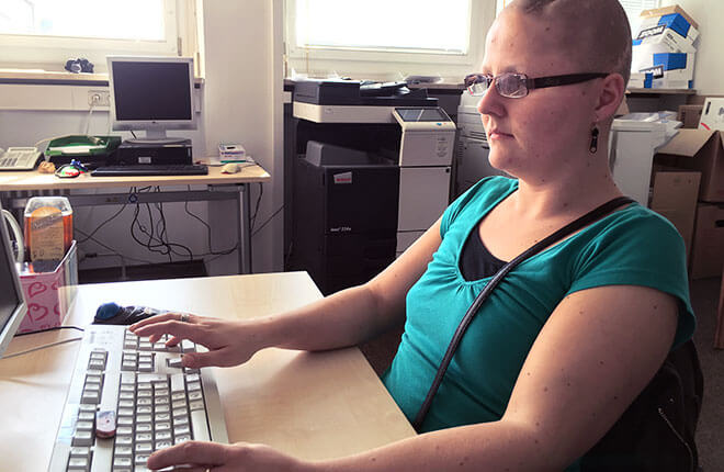 Marina sitzt in ihrem Büro an einem Computerarbeitsplatz